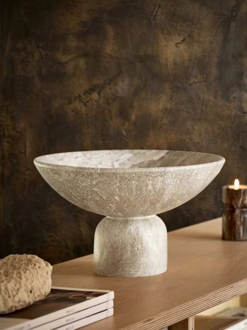Natural marble-effect resin sculptural bowl with an elongated shape and raised base, styled as a minimalist decorative accent for a small living room.
