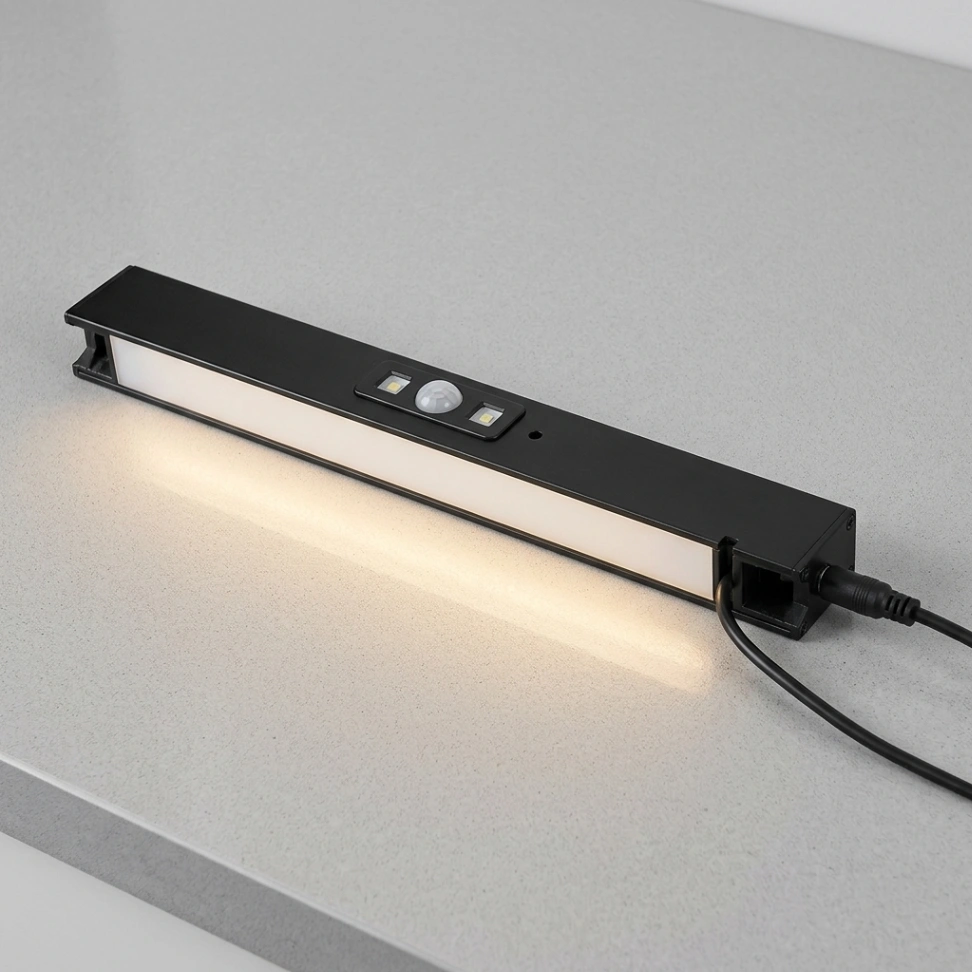 IKEA SKYDRAG anthracite LED worktop lighting strip beneath kitchen cabinets in a compact kitchenette